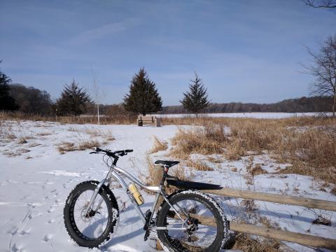 Fat bike by a bench in a field