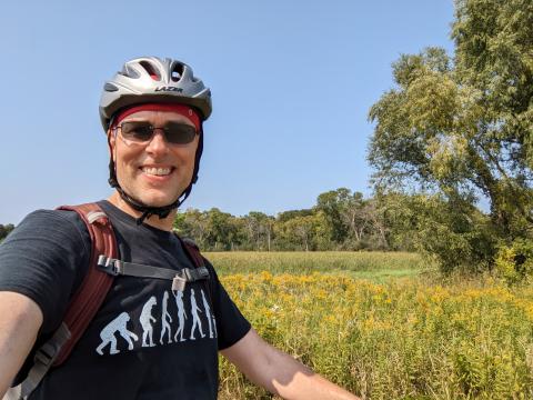 Matthew in bike helmet in a field 2022