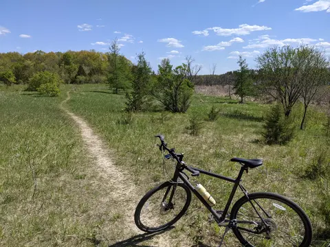 A gray bike on a singletrack path in a field