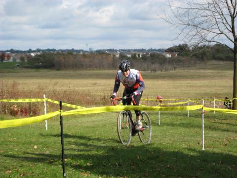 Matthew biking up a hill in a cyclocross race in 2009