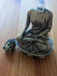 buddha statue with a broken head on a wooden surface