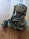 buddha statue with a broken head on a wooden surface